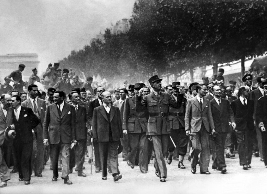 Charles De Gaulle durante su desfile por los Campos Elíseos, detrás de él los hombres de La Nueve.